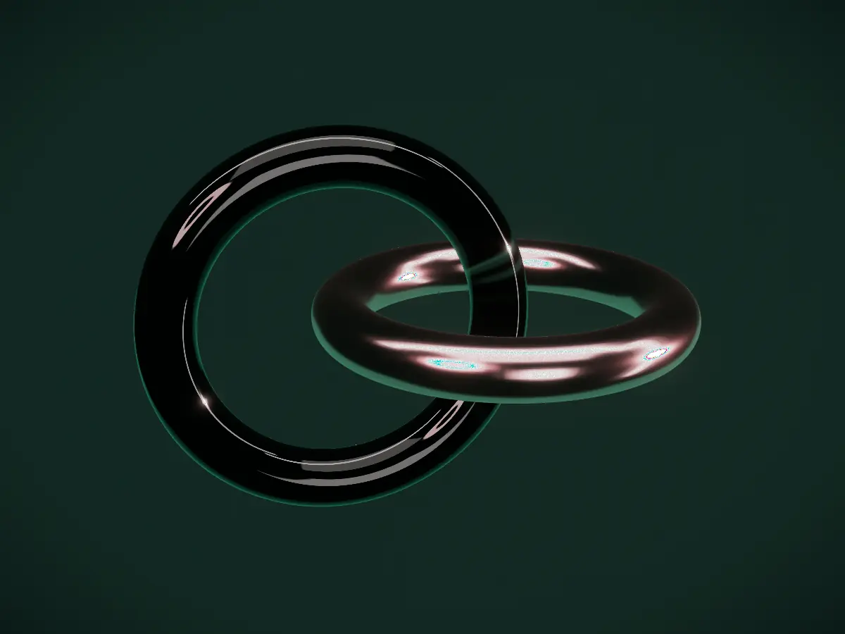 Two interlocking rings, one green glass and one blush metal.
